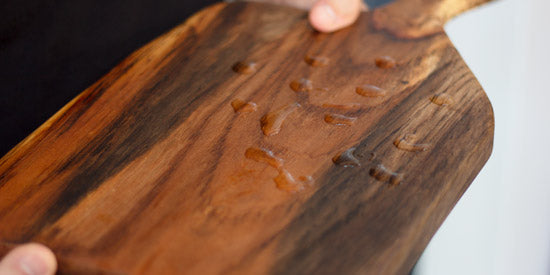 Arbor Novo wooden serving board repelling water from use of Cutting Board Perfect Oil and Woodenware Miracle Balm.