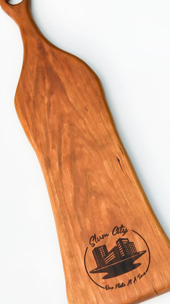 Arbor Novo large long cherry wooden serving board with Slum City logo.